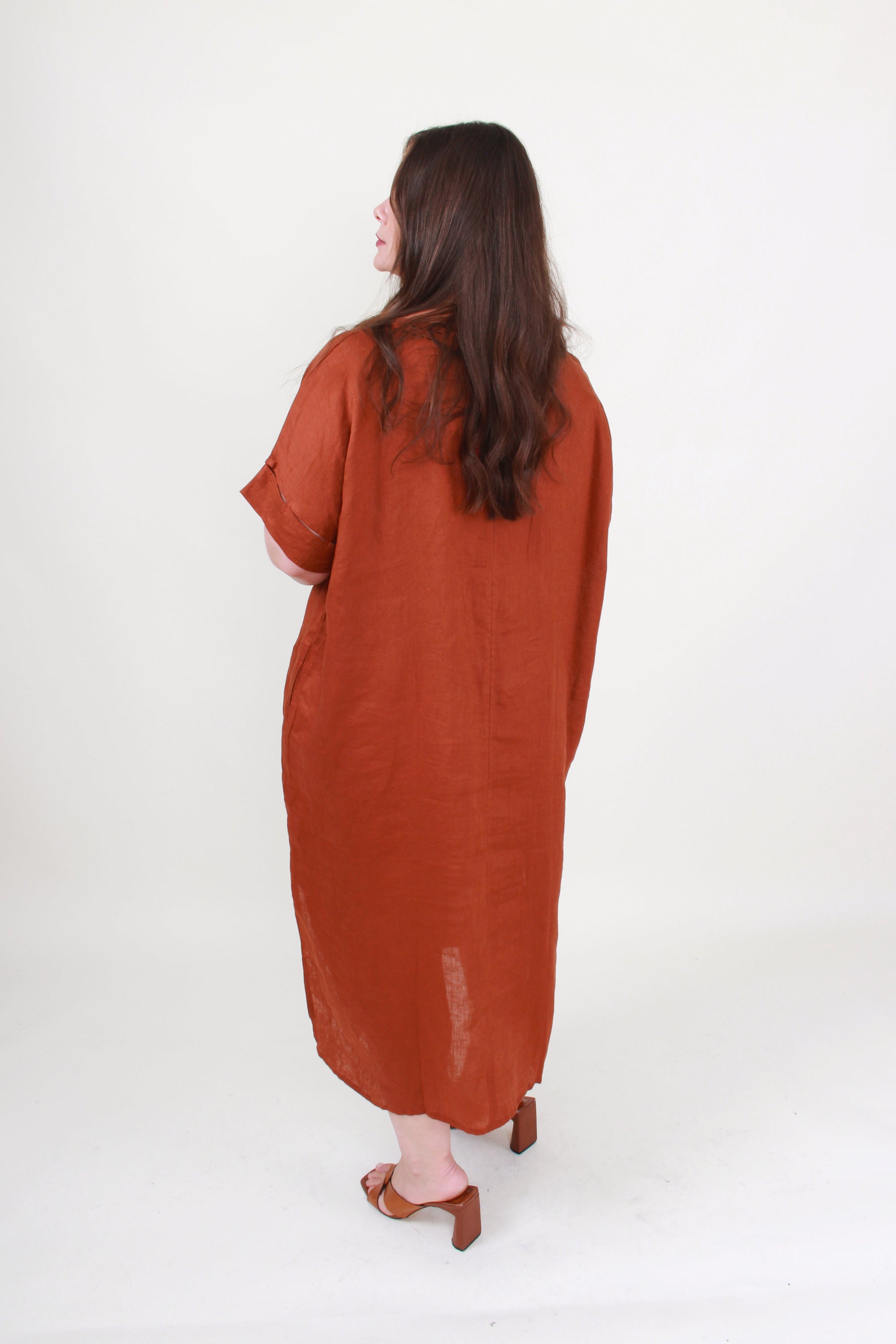 Woman wearing a rust-colored dress on a white background
