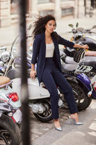 Woman in a diamante suit sitting on a motorcycle in an urban setting