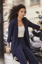 Woman in a navy diamante outfit sitting on a motorcycle in an urban setting