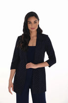 Woman wearing a dark blue diamante blazer on a white background
