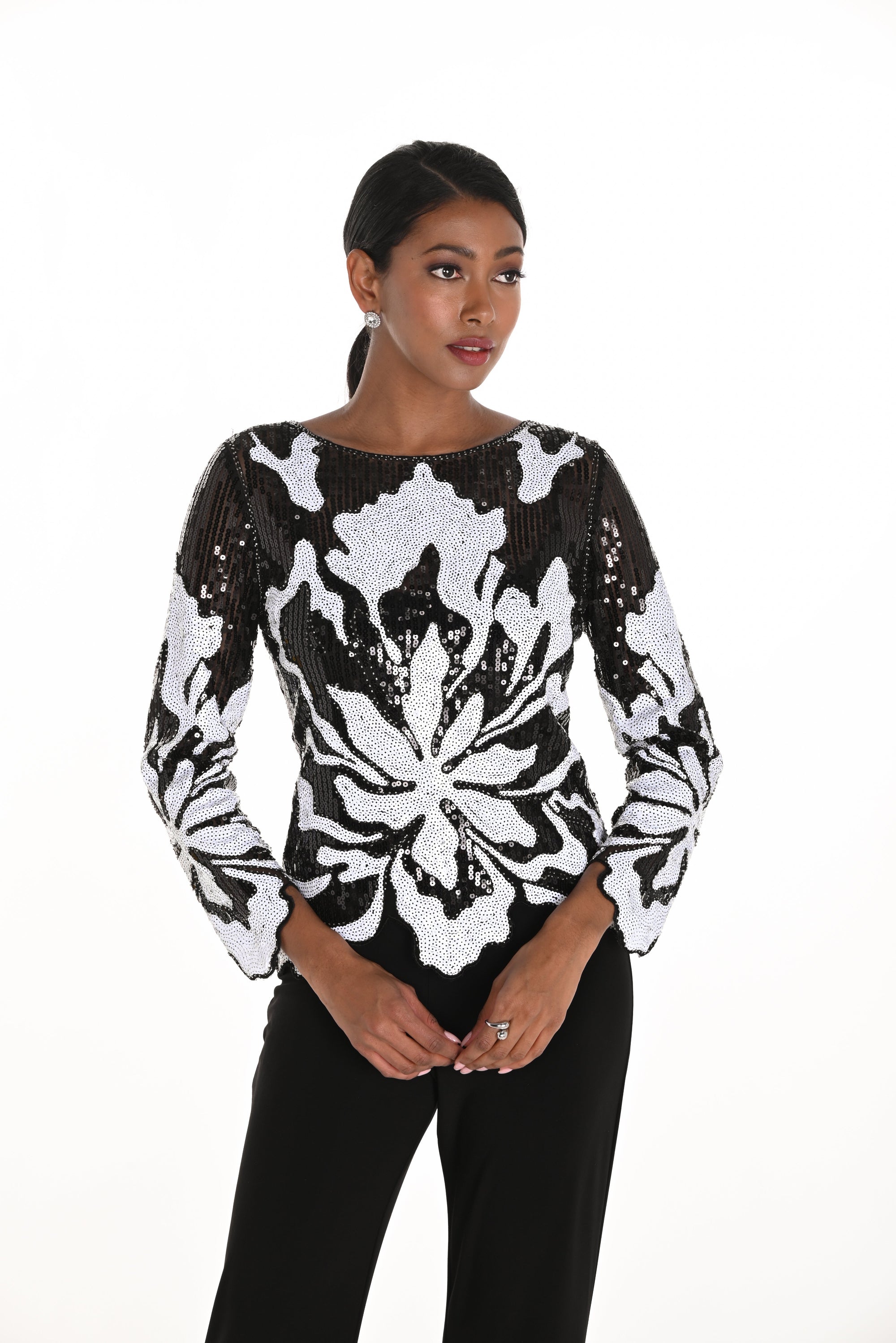 Woman wearing a black and white sequin floral top
