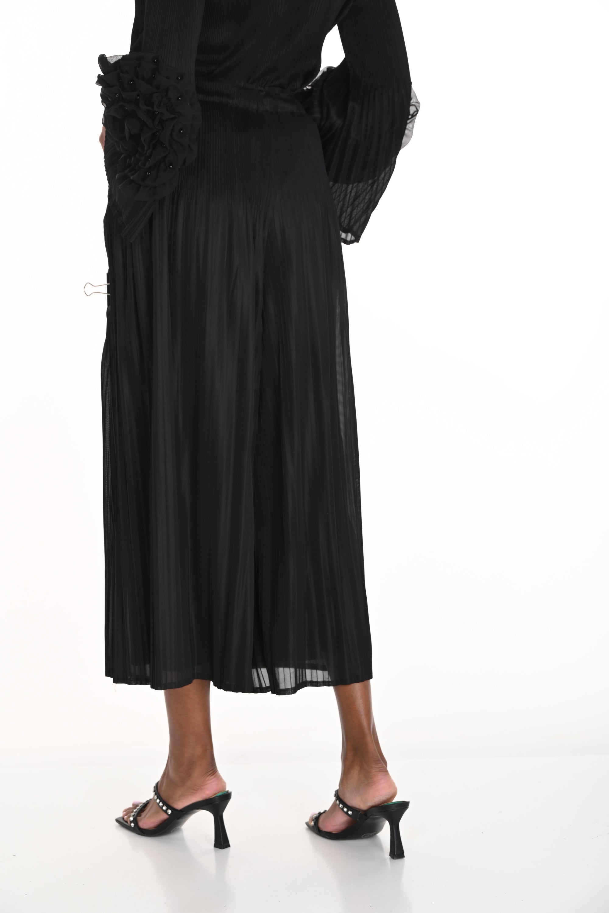 pleated black wide leg pants worn by model against white background back