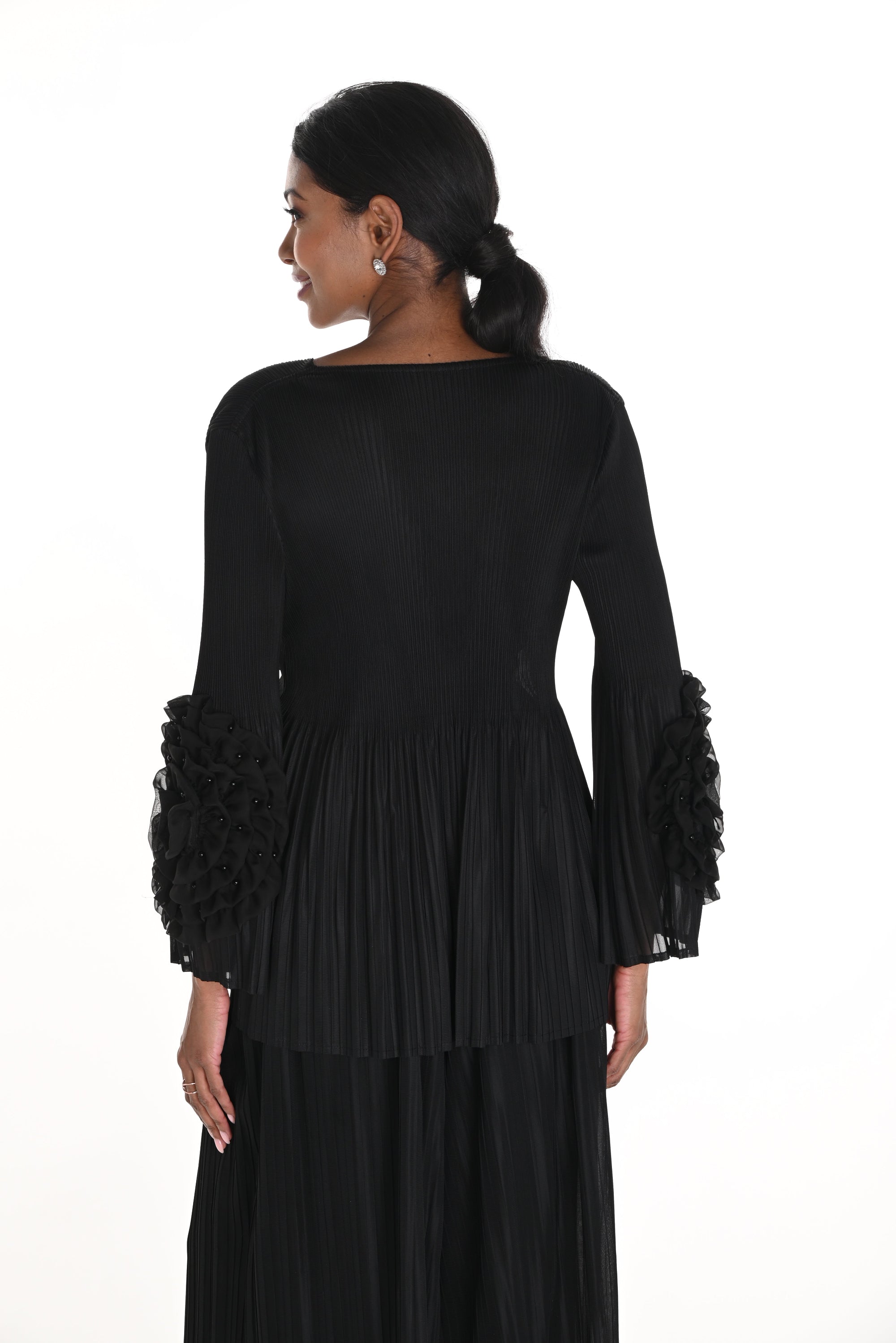 Woman wearing a black dress with ruffled sleeves on a white background back