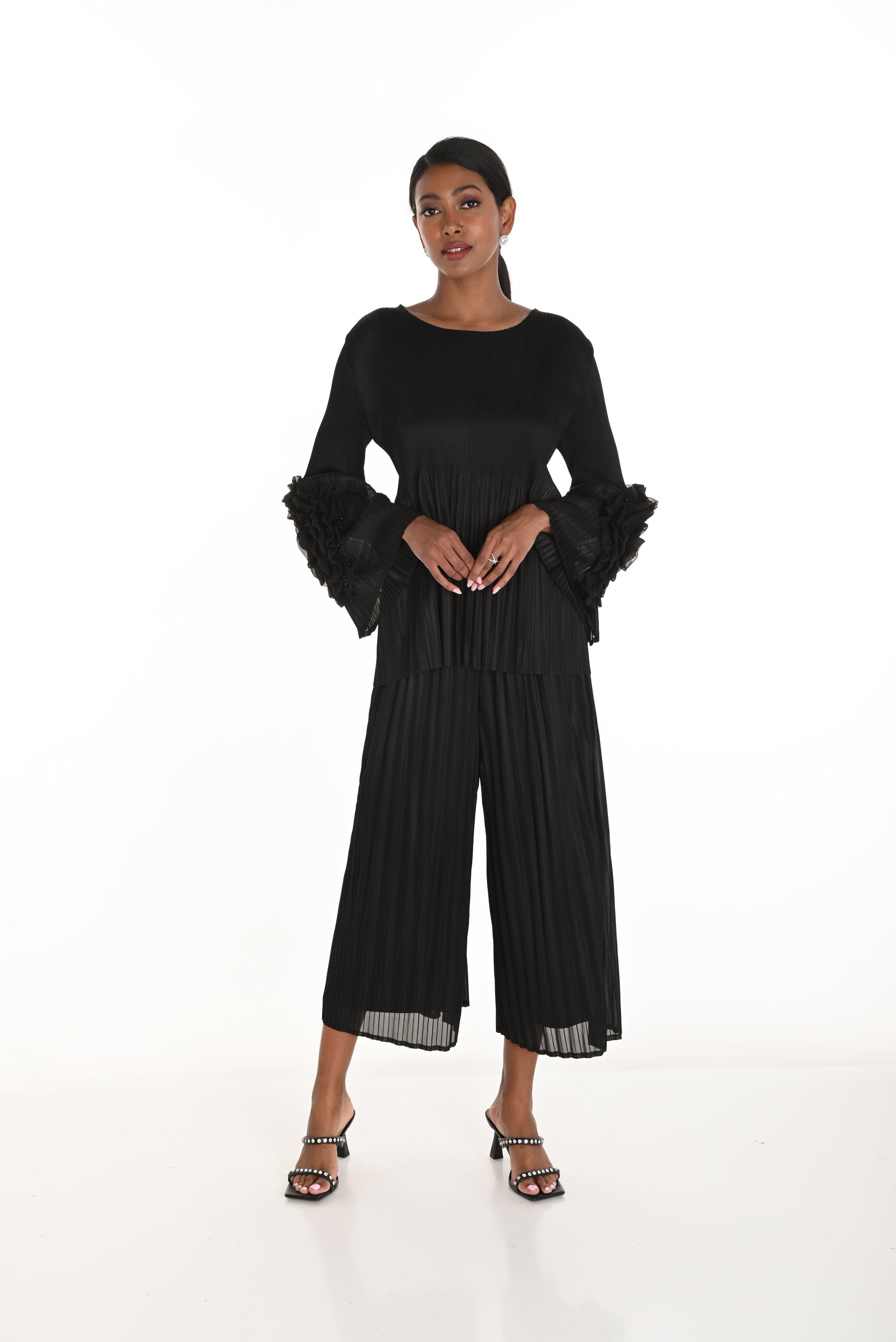 pleated black wide leg pants and top worn by model against white background