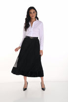 Woman wearing a white blouse and black pleated skirt on a white background