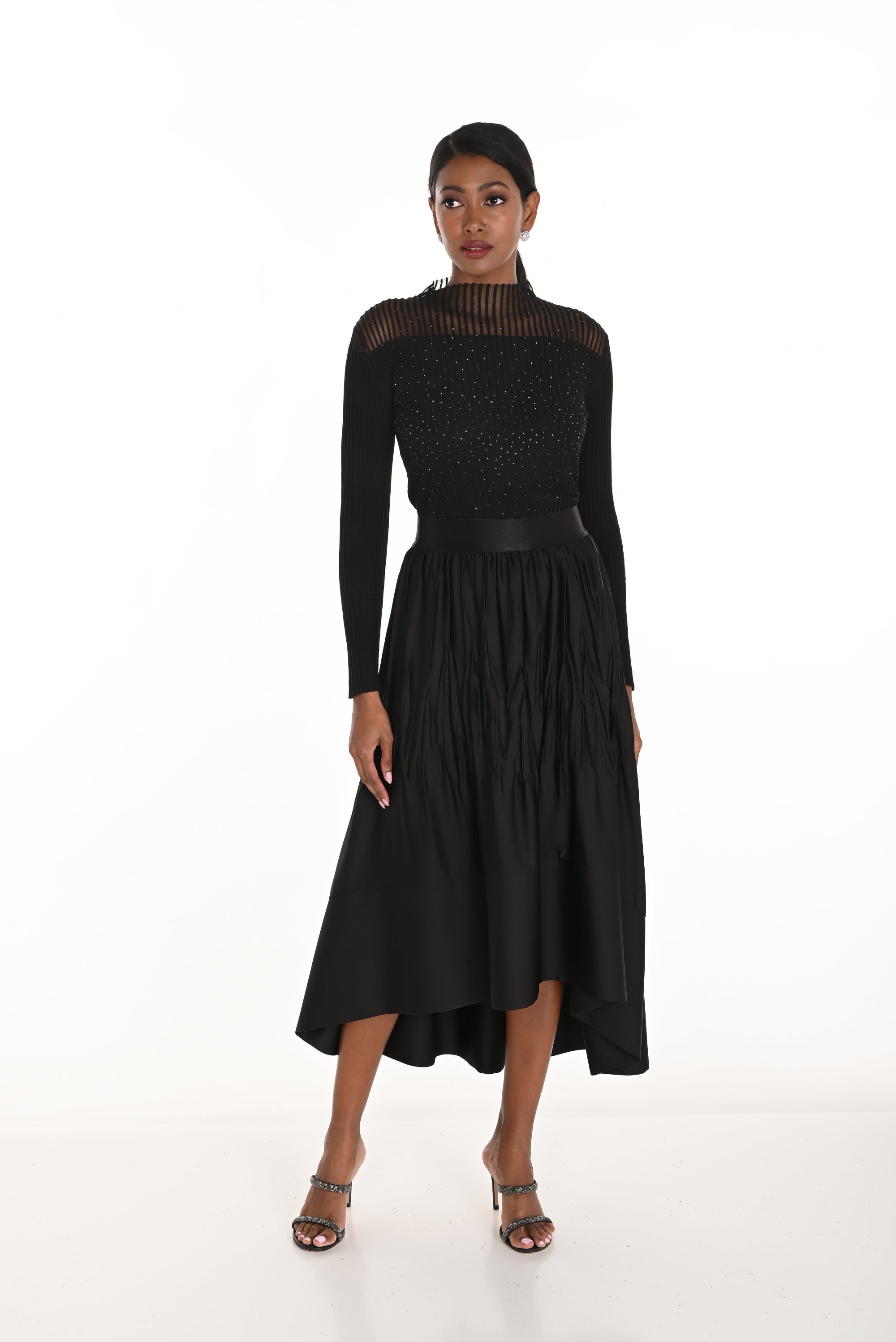 high low pleated black skirt and black long sleeve top worn by model