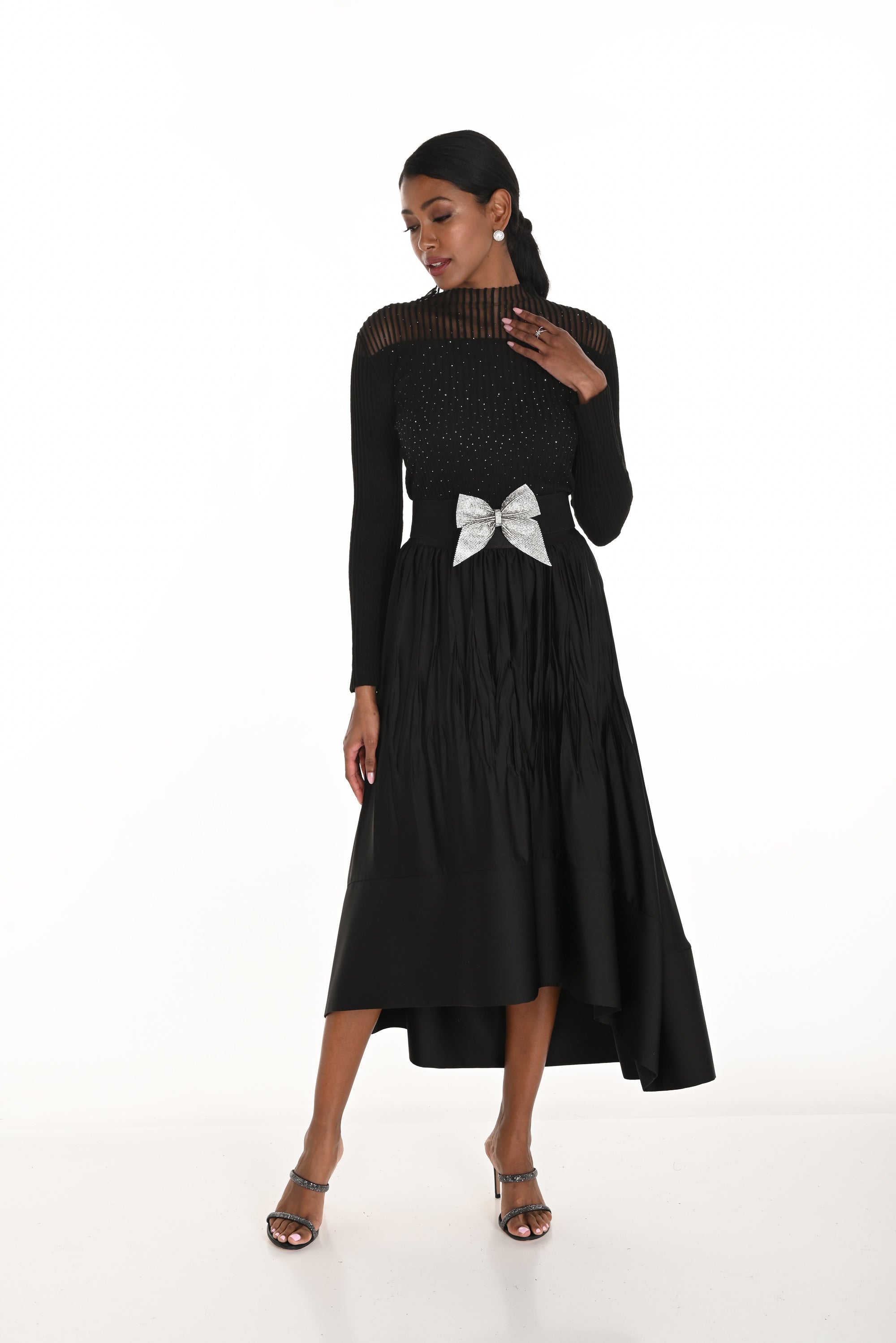 high low pleated black skirt and black long sleeve top worn by model