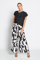 Womens wide leg black white geometric pant with black top worn by model 