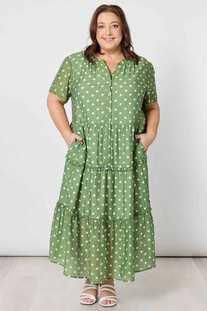 Woman wearing a green polka dot dress on a white background