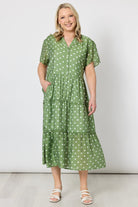Woman wearing a green polka dot dress on a white background