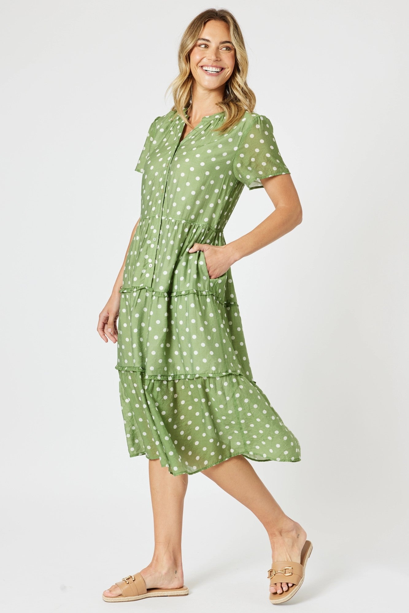 Woman wearing a green polka dot dress on a white background