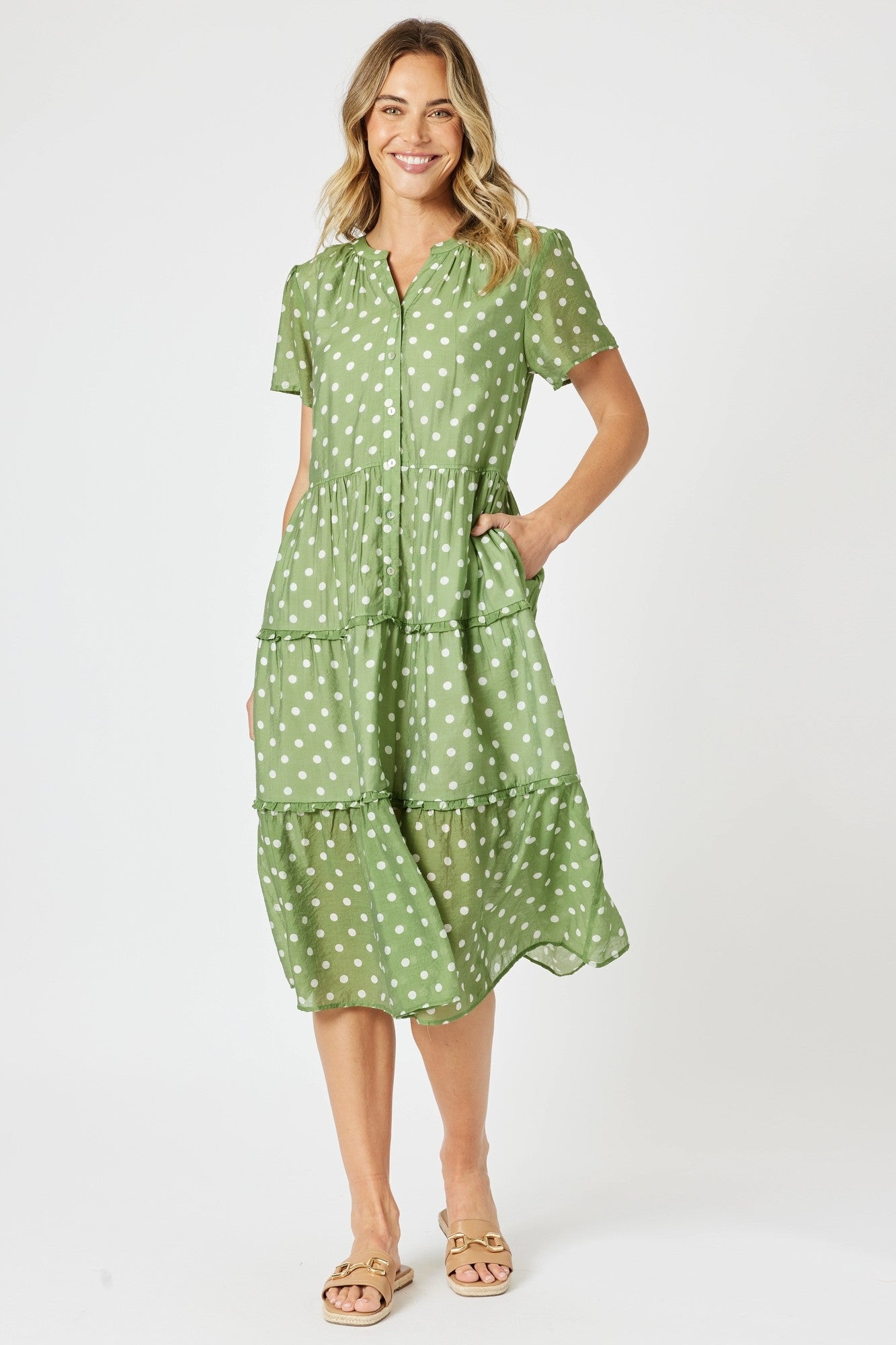Woman wearing a green polka dot dress on a white background