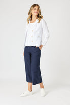 boxy linen blazer in white with navy pants worn by model 