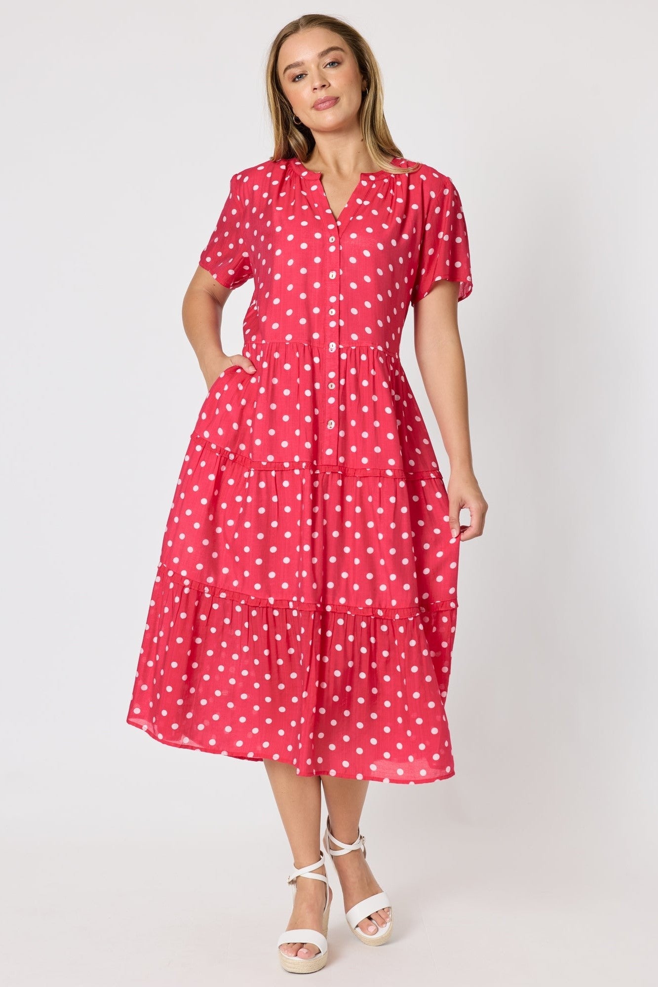 Woman wearing a red polka dot dress against a white background