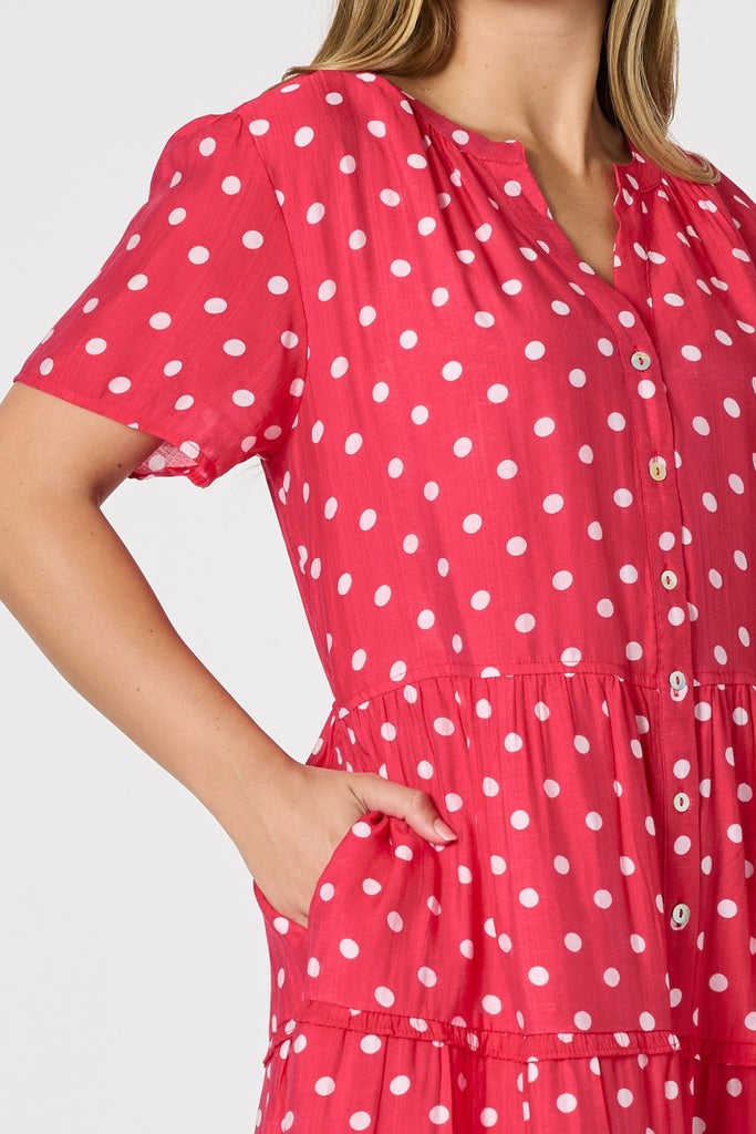 Woman wearing a red polka dot dress against a white background