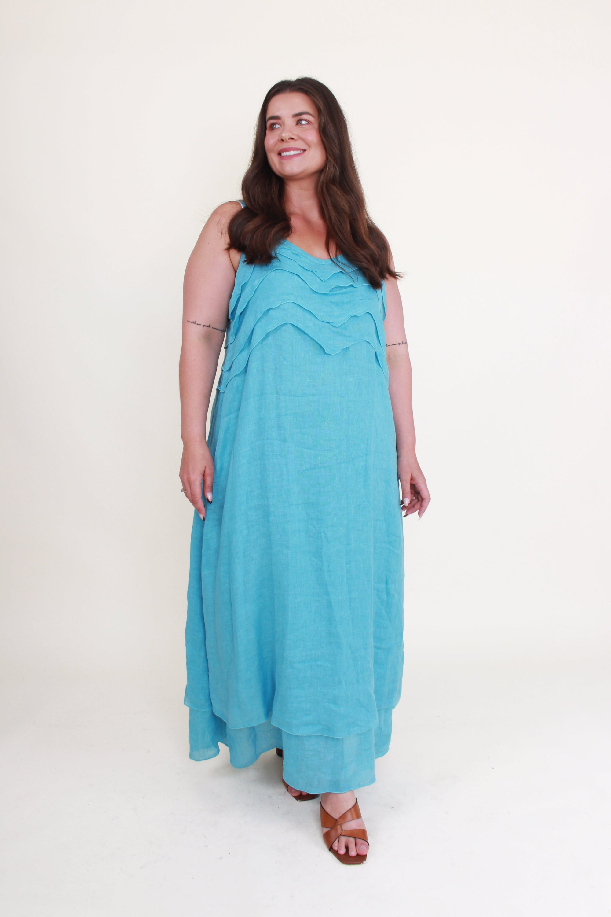Woman wearing a turquoise maxi dress on a white background
