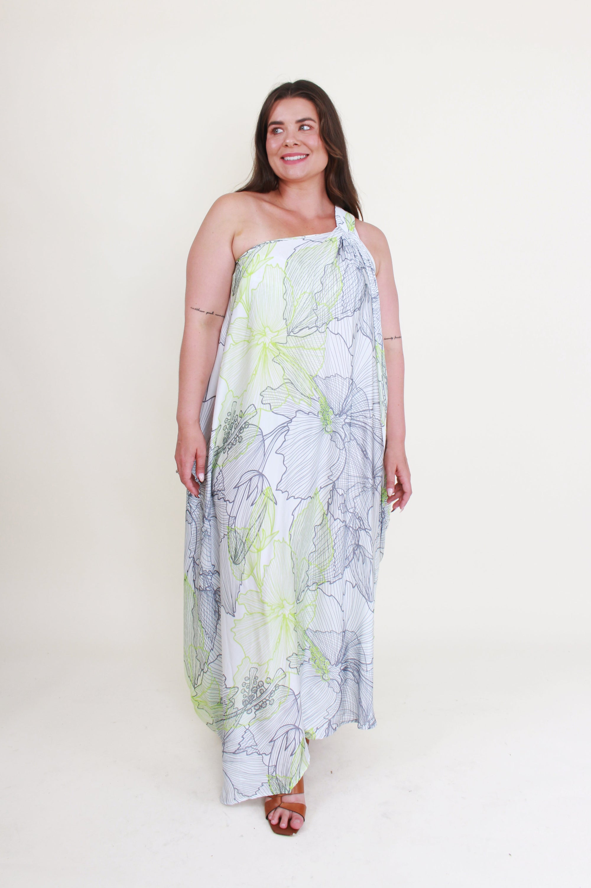 Woman wearing a floral one-shoulder dress on a white background