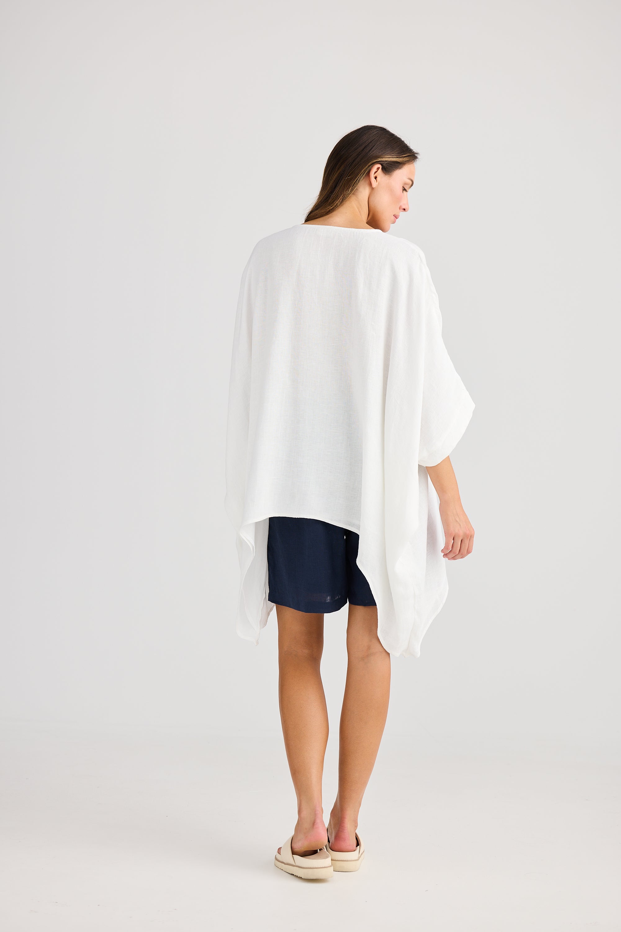 oversized high low white top with navy shorts worn by model back view