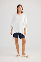oversized high low white top with navy shorts worn by model 