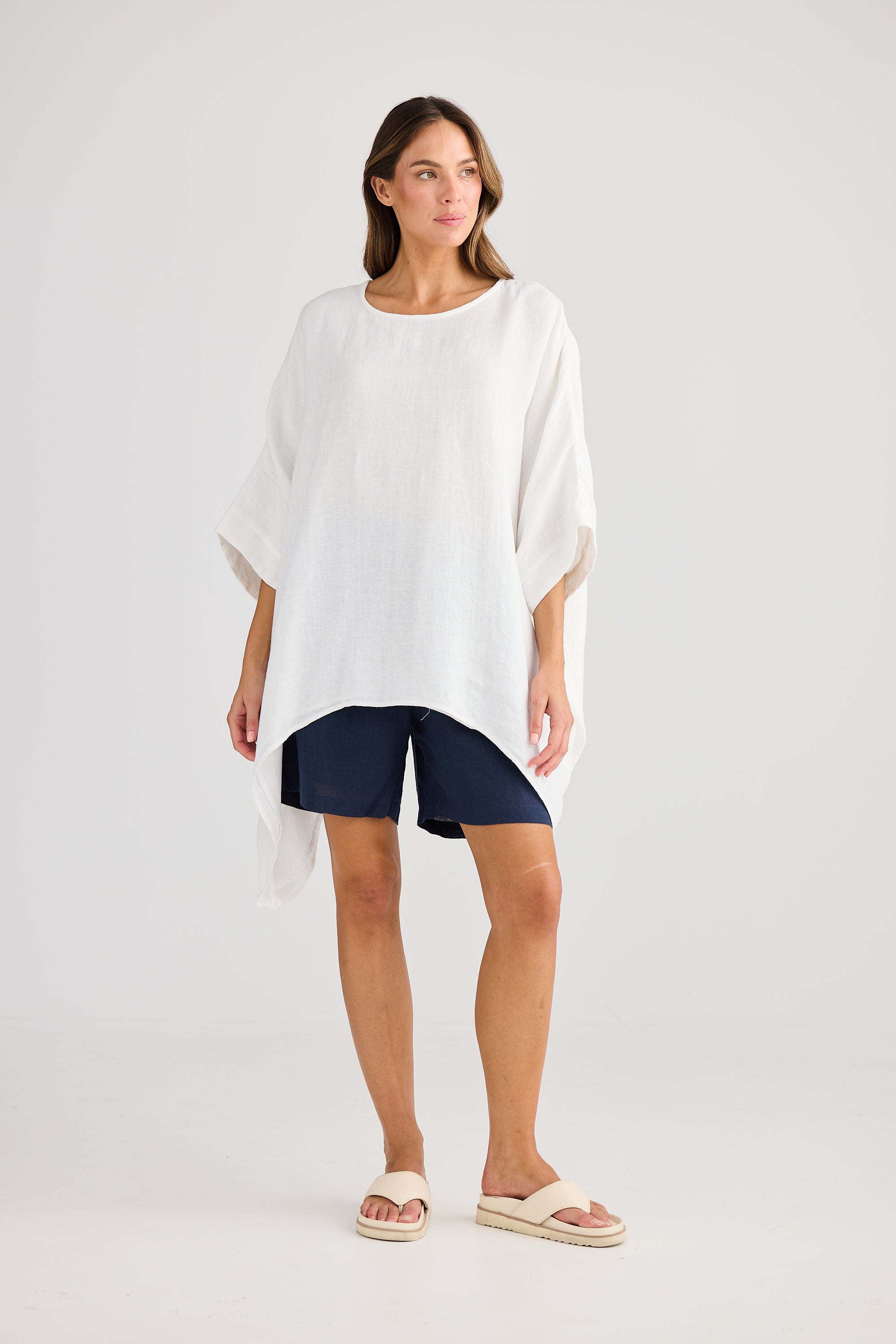 oversized high low white top with navy shorts worn by model 