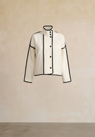 White jacket with black accents on a beige background