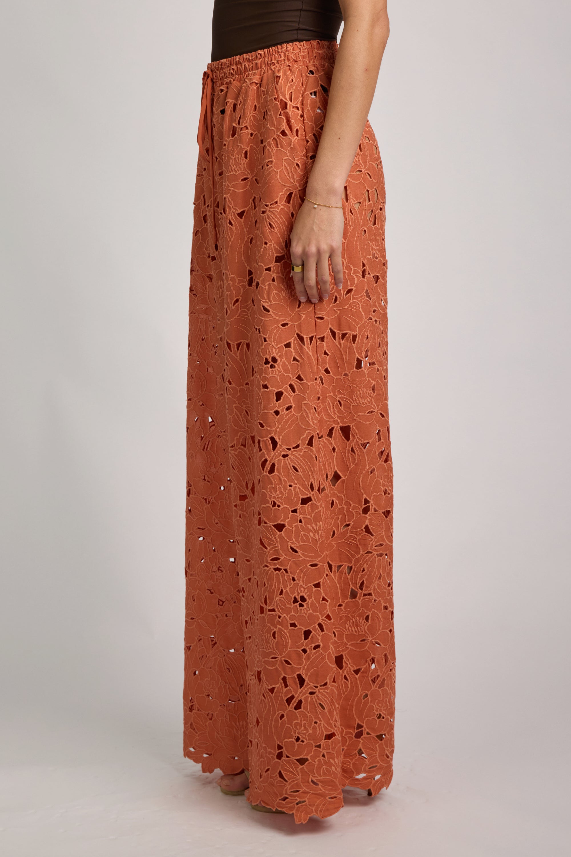 Long orange lace skirt worn by a person on a plain background