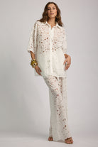 Woman wearing a white floral outfit on a gray background