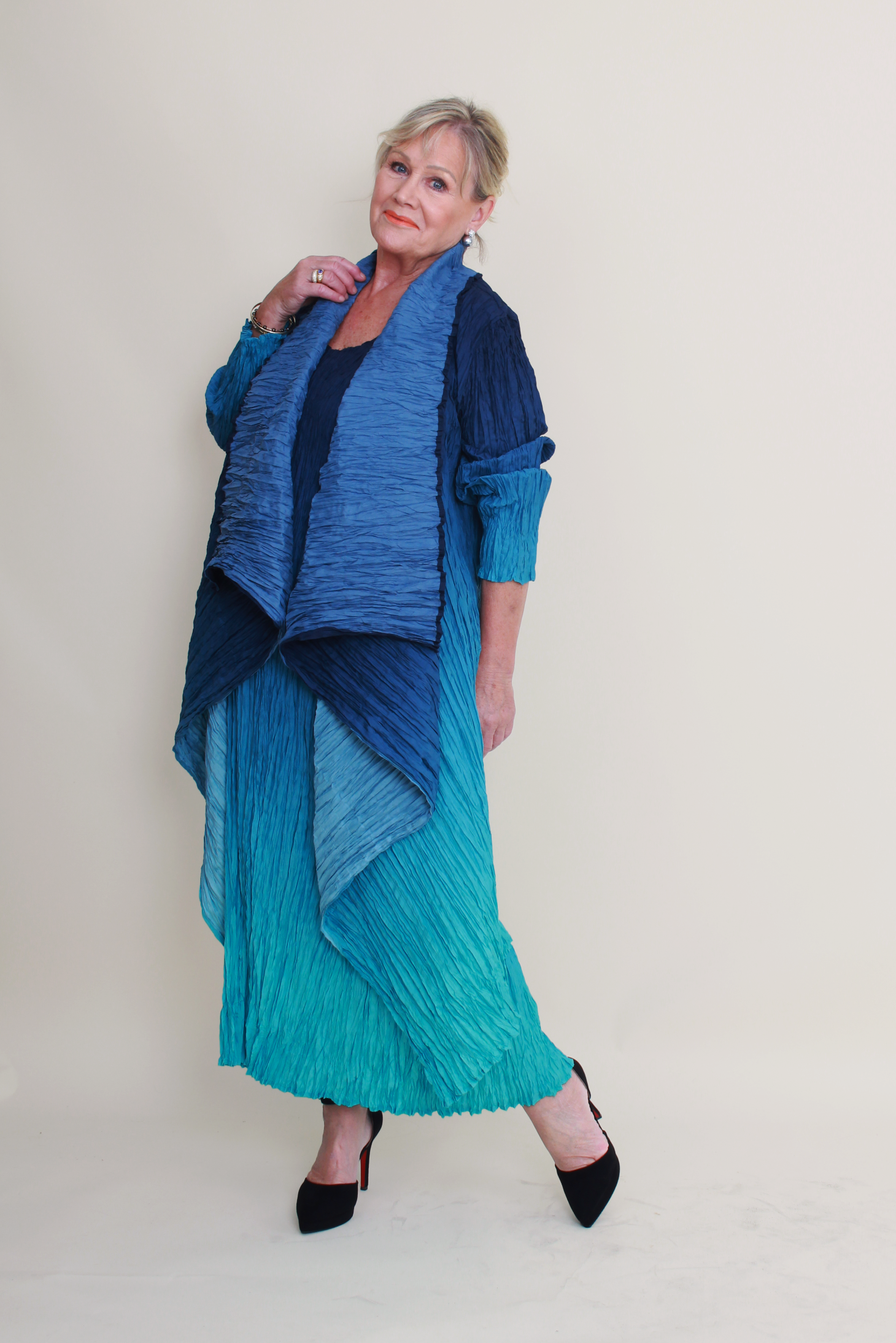 Woman wearing a blue and green outfit against a plain background