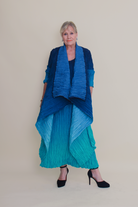 Woman wearing a blue and green outfit against a plain background