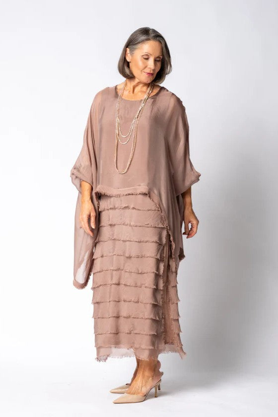 Woman wearing a layered dress with a plain background