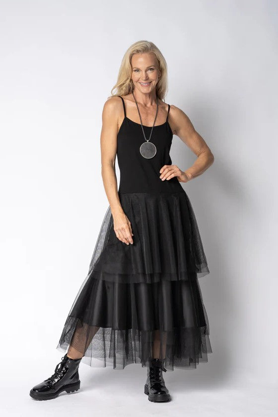 Woman wearing a black dress with a sheer overlay skirt on a white background