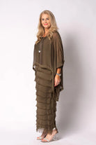 Woman wearing a long, layered moss green dress against a white background