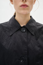 Close-up of a black jacket with buttons on a white background