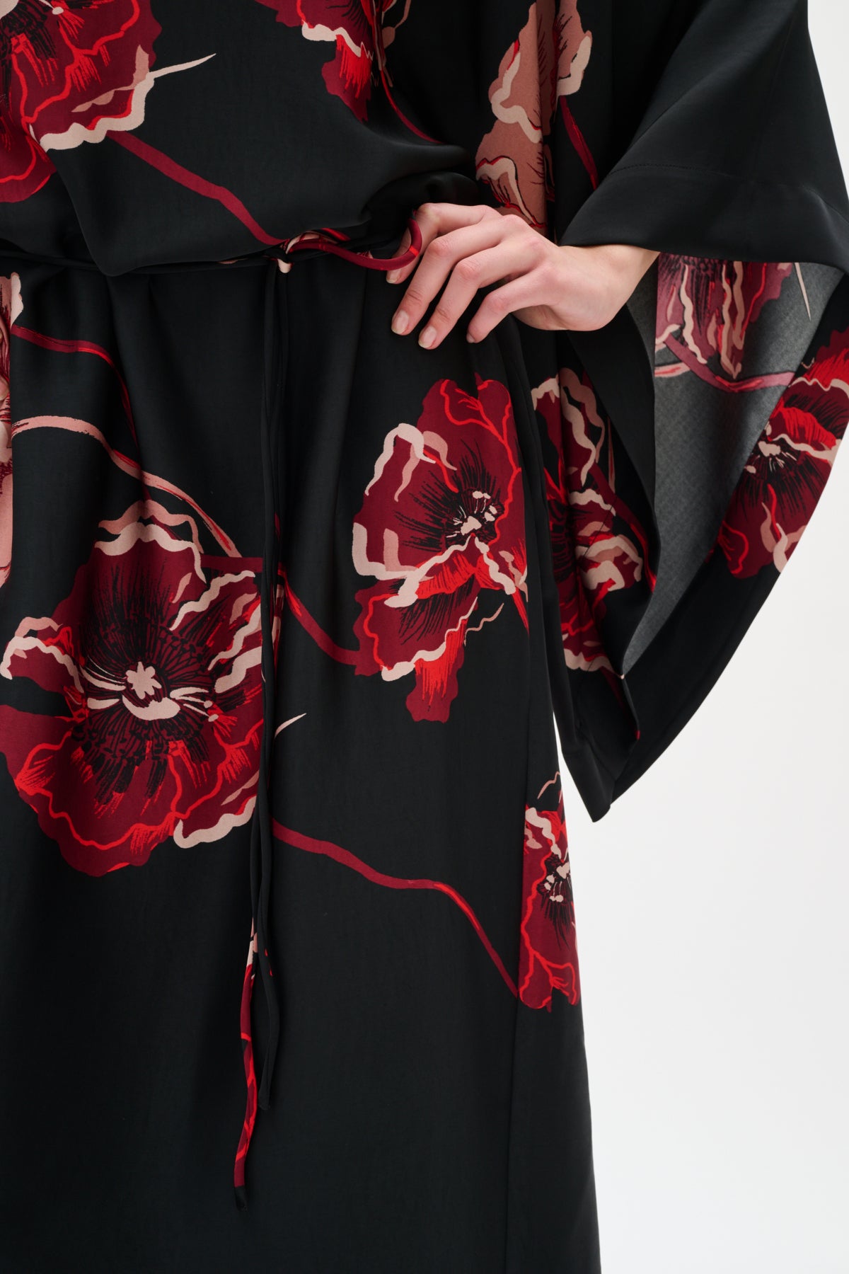 Black garment with red floral patterns on a white background close up
