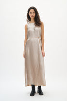 Woman wearing a silver beige pleated dress on a white background