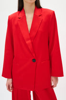 Red suit jacket with a black button on a white background