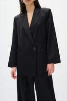 Person wearing a black suit on a white background