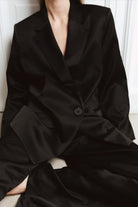 Person wearing a black suit with a blurred background