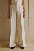 Person wearing beige and white pants against a neutral background
