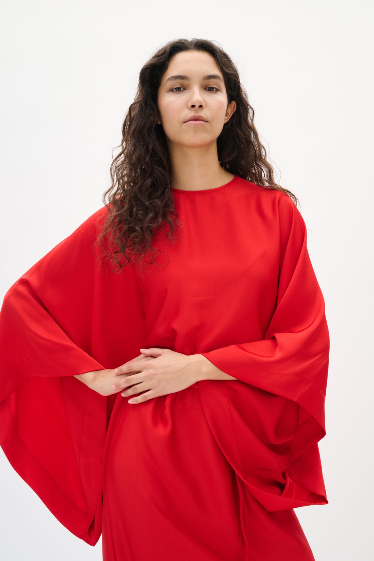 Person wearing a red dress against a white background