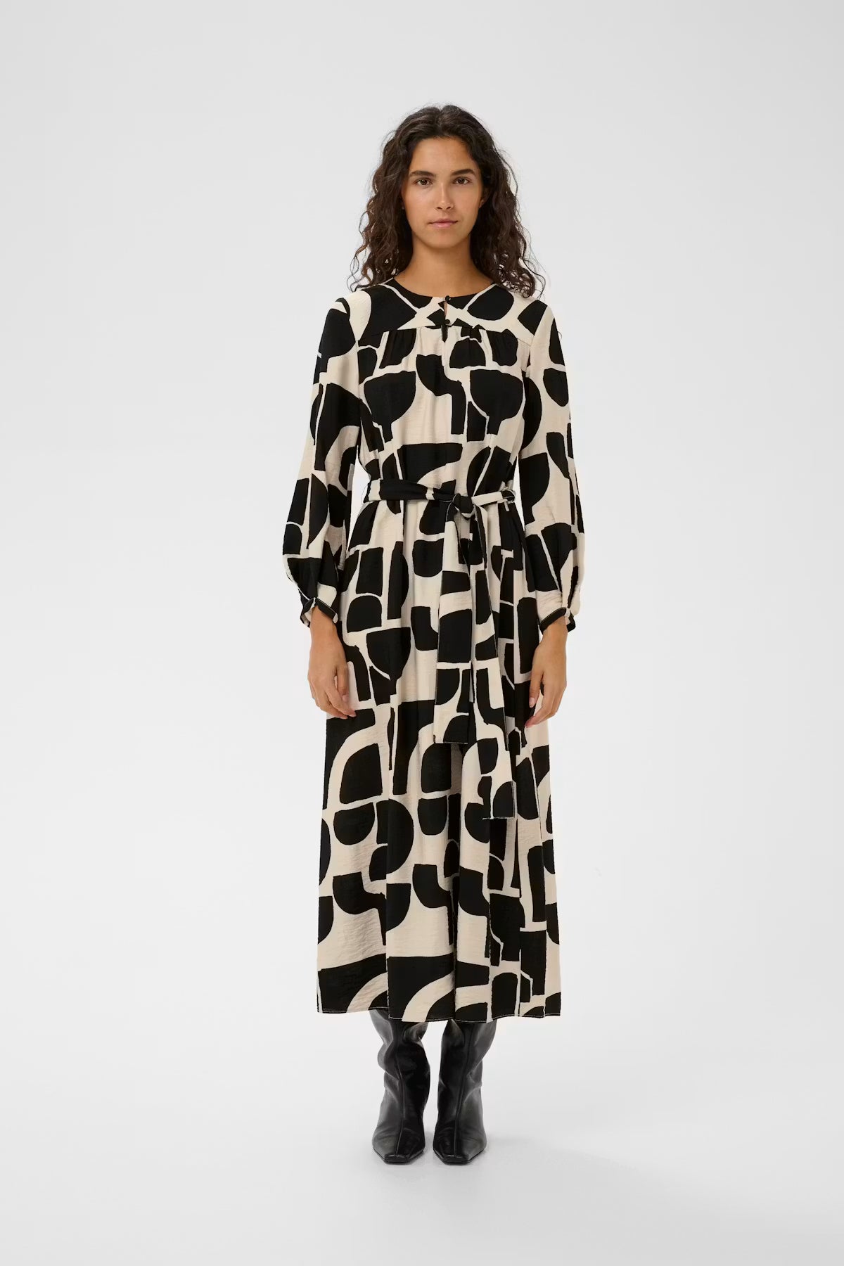 Woman wearing a black and white patterned dress on a white background