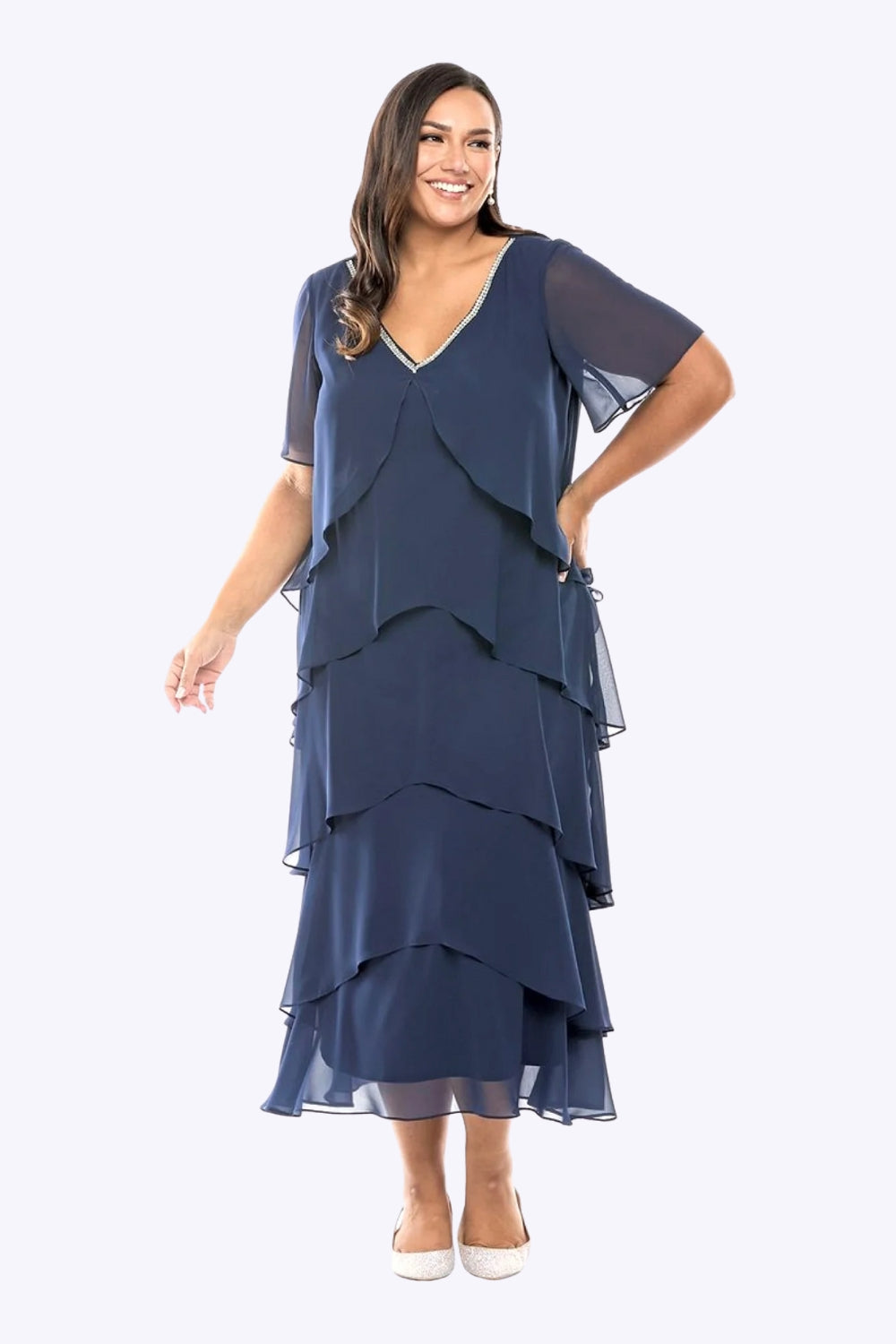 Woman wearing a navy blue layered dress on a white background