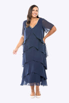 Woman wearing a navy blue layered dress on a white background