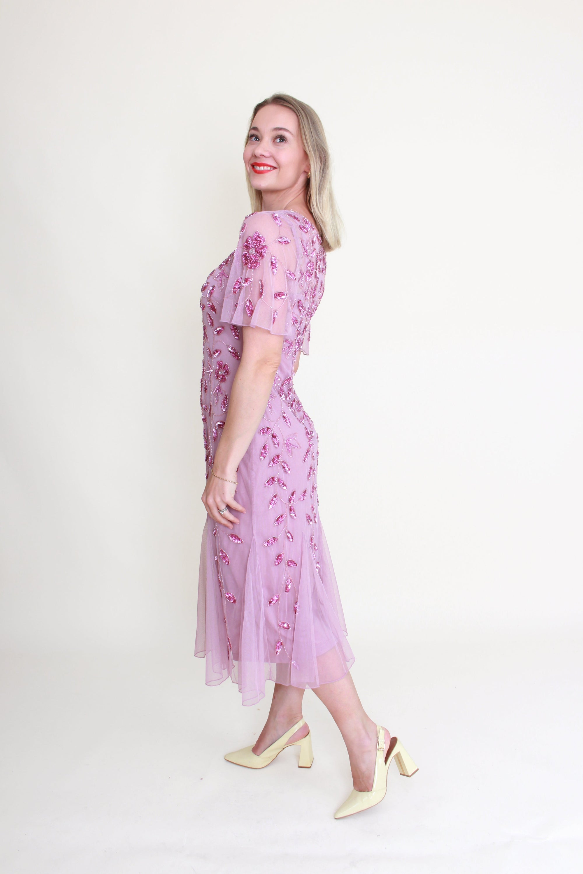 Woman wearing a pink floral dress against a white background