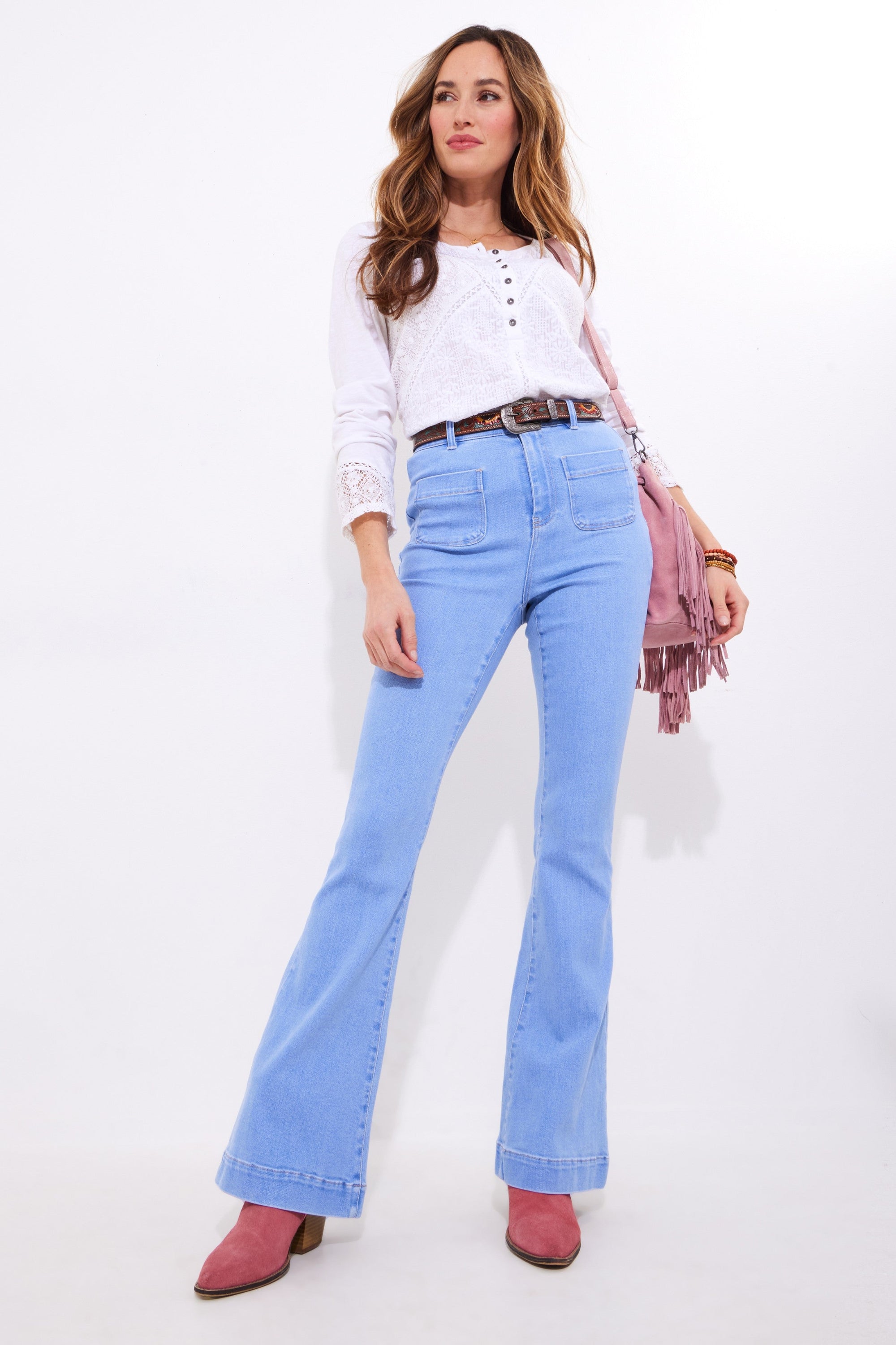 light wash denim flare jean and white blouse worn by model 