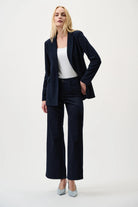 Woman wearing dark blue jacket and jeans with a white top on a white background