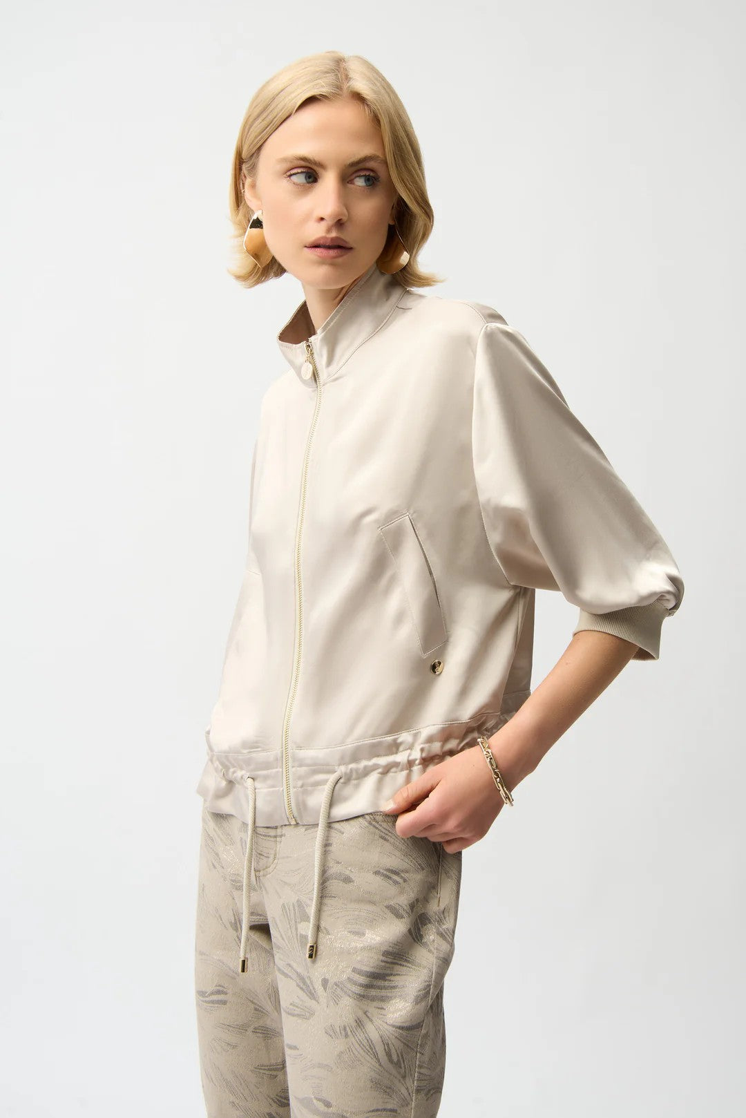 Woman wearing a beige jacket and pants on a white background