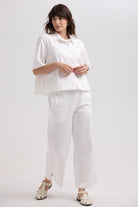 Woman wearing a white outfit on a plain background