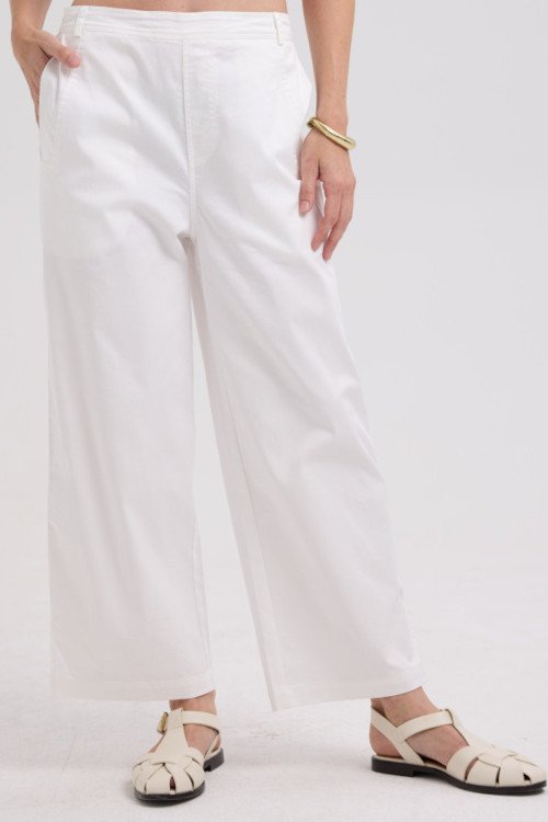 Person wearing white pants on a plain background