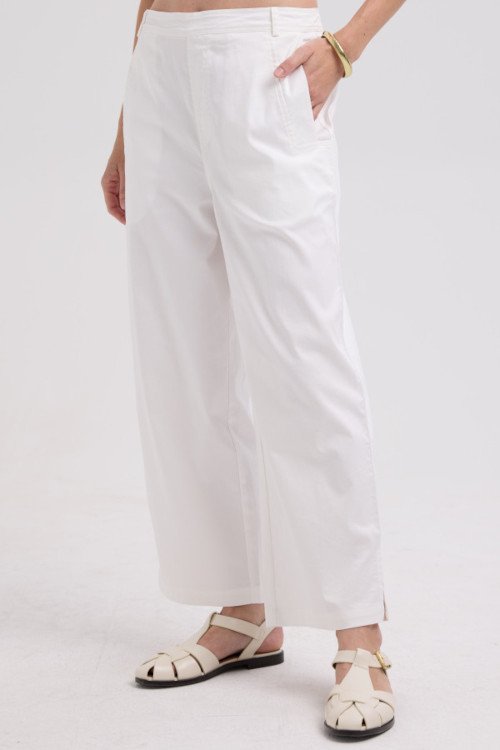 Person wearing white pants on a plain background